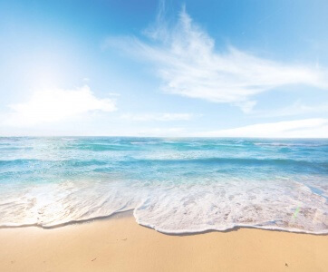 Picture of a sandy beach looking out to a perfect blue sea